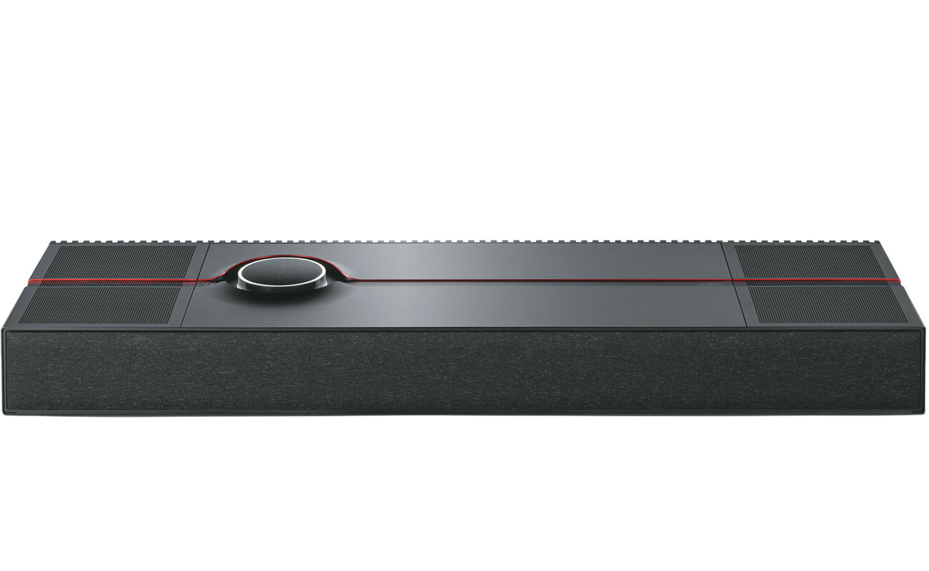 Système tout-en-un Naim Mu-so Utopia vu de trois quarts dessus, coffret noir d'un mètre de large à grilles rainurées, liseré rouge et molette de commande rétroéclairée