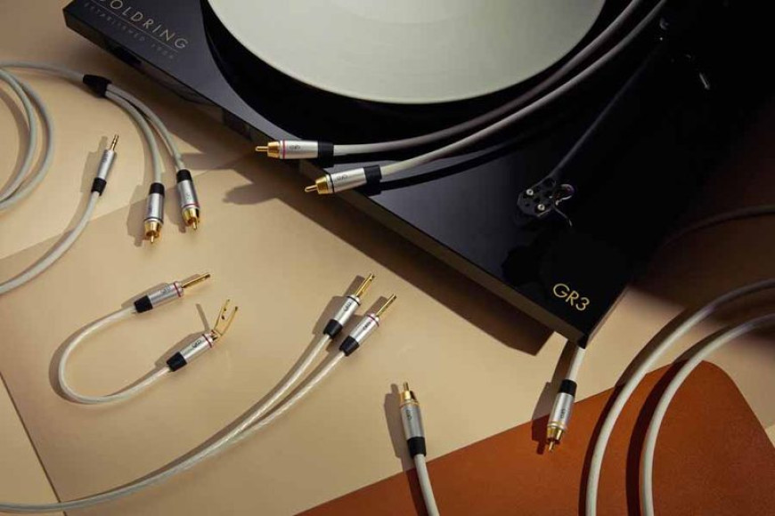Famille de câbles analogiques QED Performance à gaine claire et fiches gris argent : modulation RCA branchée sur une platine Goldring GR3, câble jack 3,5 mm vers RCA, câbles d'enceinte à fiches bananes et fourches Airloc