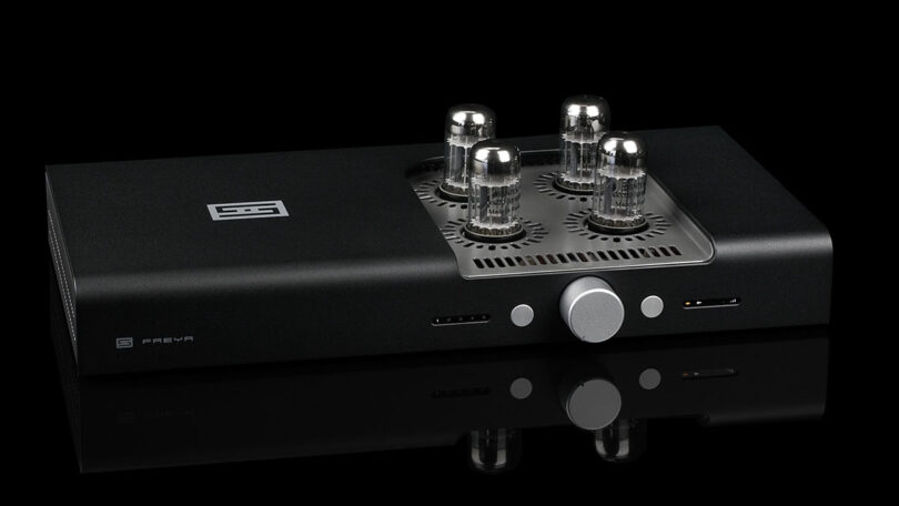 réamplificateur symétrique Schiit Freya 2 en finition noire, vu de trois quarts, avec ses quatre lampes octales émergeant de la grille ajourée du capot, son bouton de volume central argenté et ses deux afficheurs en façade