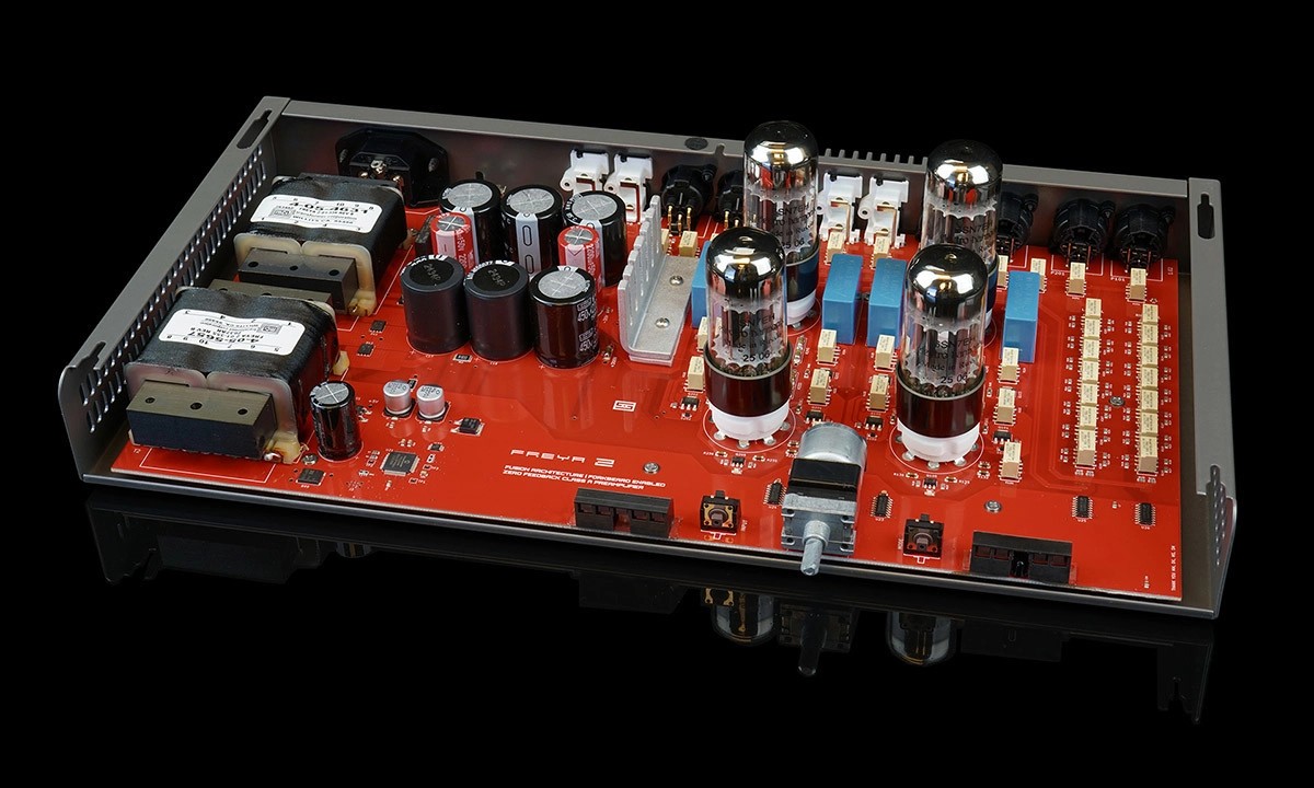 Intérieur du préamplificateur Schiit Freya 2 capot retiré, avec son circuit imprimé rouge, ses deux transformateurs, ses condensateurs de filtrage, ses quatre lampes octales et les rangées de relais de l'atténuateur de volume