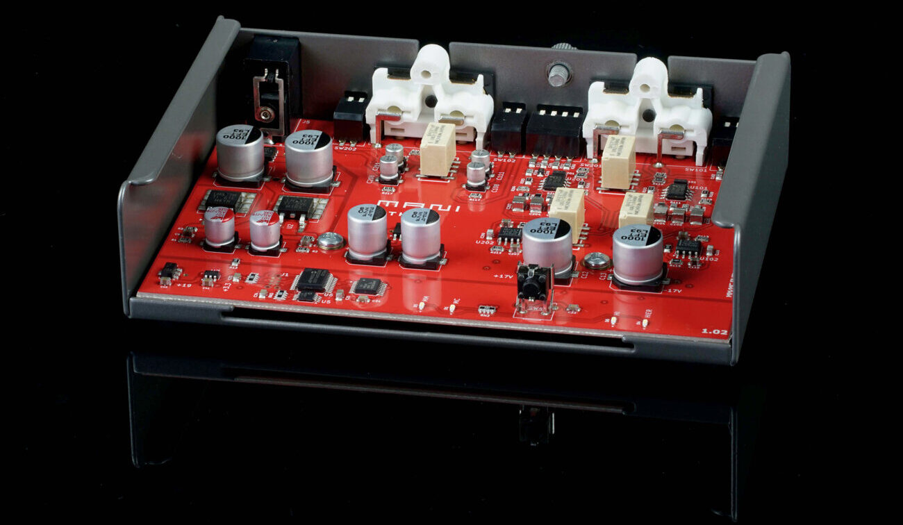 Vue interne du Schiit Mani 3 capot retiré : carte rouge avec condensateurs, relais de commutation et composants montés en surface