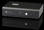 Préampli phono Schiit Mani 3 noir vu de face, voyants MM et MC, bouton de sélection et indicateurs de gain en façade, sur fond noir
