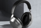 Casque sans fil Sennheiser HDB 630 en finition Lunar Silver vu de trois quarts, coques argentées au rendu mat, arceau noir en similicuir japonais IDEATEX et coussinets circum-auriculaires noirs, posé contre un mur de béton gris