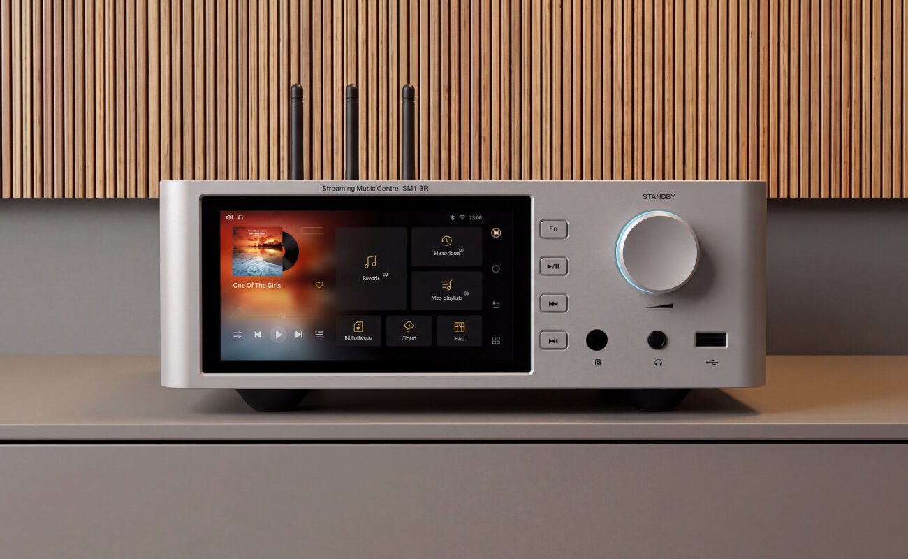 Shanling SM1.3R HD en finition argent posé sur un meuble, avec son écran tactile 2K de 5,98 pouces, ses trois antennes Wi-Fi et Bluetooth, son bouton de volume rétroéclairé et sa prise casque en façade