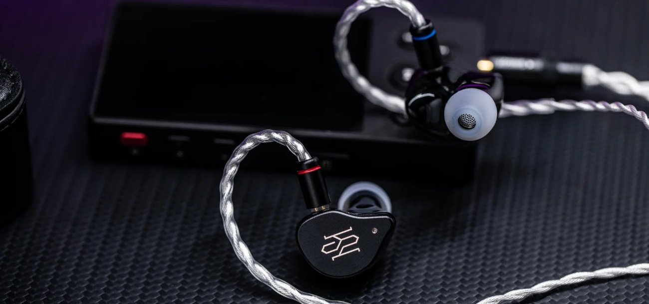 Intras SIMGOT SuperMix 5 noirs branchés sur un baladeur audio, câble tressé argenté en cuivre OCC de structure Litz, connecteurs 2 broches à bagues rouge et bleue