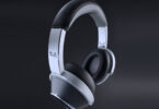 Casque sans fil T+A Solitaire T Pro en finition Nightflight, arceau aluminium brossé et coques noires à anneau argenté, logo T+A sur la branche, sur fond sombre