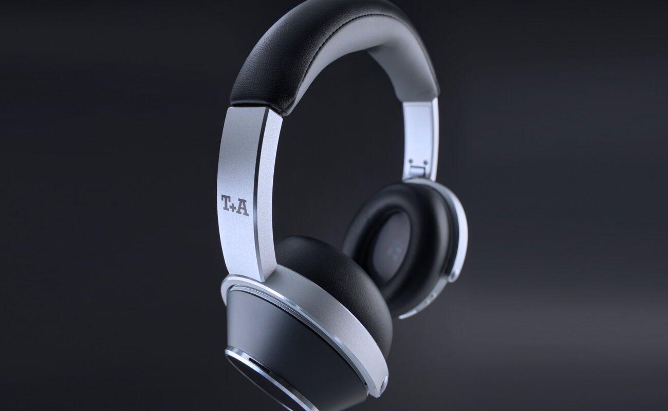 Casque sans fil T+A Solitaire T Pro en finition Nightflight, arceau aluminium brossé et coques noires à anneau argenté, logo T+A sur la branche, sur fond sombre