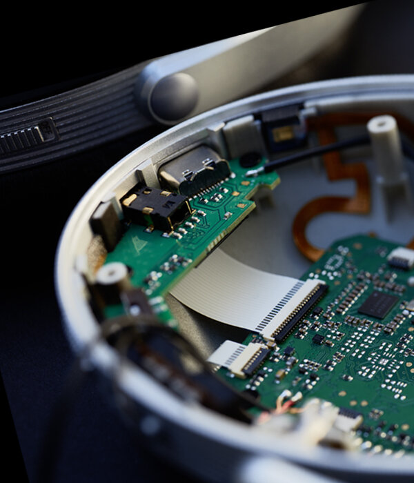 Vue interne officielle d'une oreillette du T+A Solitaire T Pro ouverte : circuits imprimés verts, nappes de liaison, port USB-C et prise jack logés dans la coque en aluminium