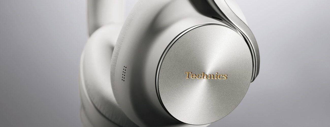 Casque sans fil Technics EAH-A1000 coloris Platinum Greige, gros plan sur l'écouteur avec sa coque en métal à finition circulaire, le logo Technics doré et l'arceau Flow Arm
