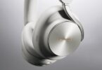 Casque sans fil Technics EAH-A1000 coloris Platinum Greige, gros plan sur l'écouteur avec sa coque en métal à finition circulaire, le logo Technics doré et l'arceau Flow Arm