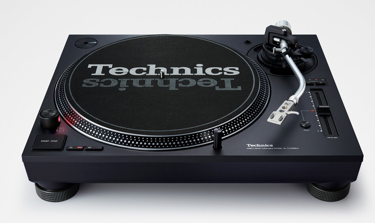 Technics SL-1210MKX vue de face avec plateau en aluminium, feutrine Technics, bras argent poli, curseur de pitch à droite et boutons start/stop et 33/45 tours