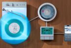 Système Trettitre Retro Ambient accroché sur un mur en bois : platine TTT-LP3 éclairée avec vinyle bleu, lecteur CD DP3, lecteur cassette CP3 et smartphone sur le support W-RACK