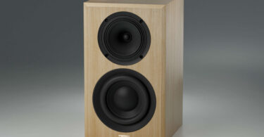 Enceinte active True Tone T1 Signature en finition chêne, sans grille : haut-parleur coaxial en haut et boomer en bas de la façade, sur fond gris